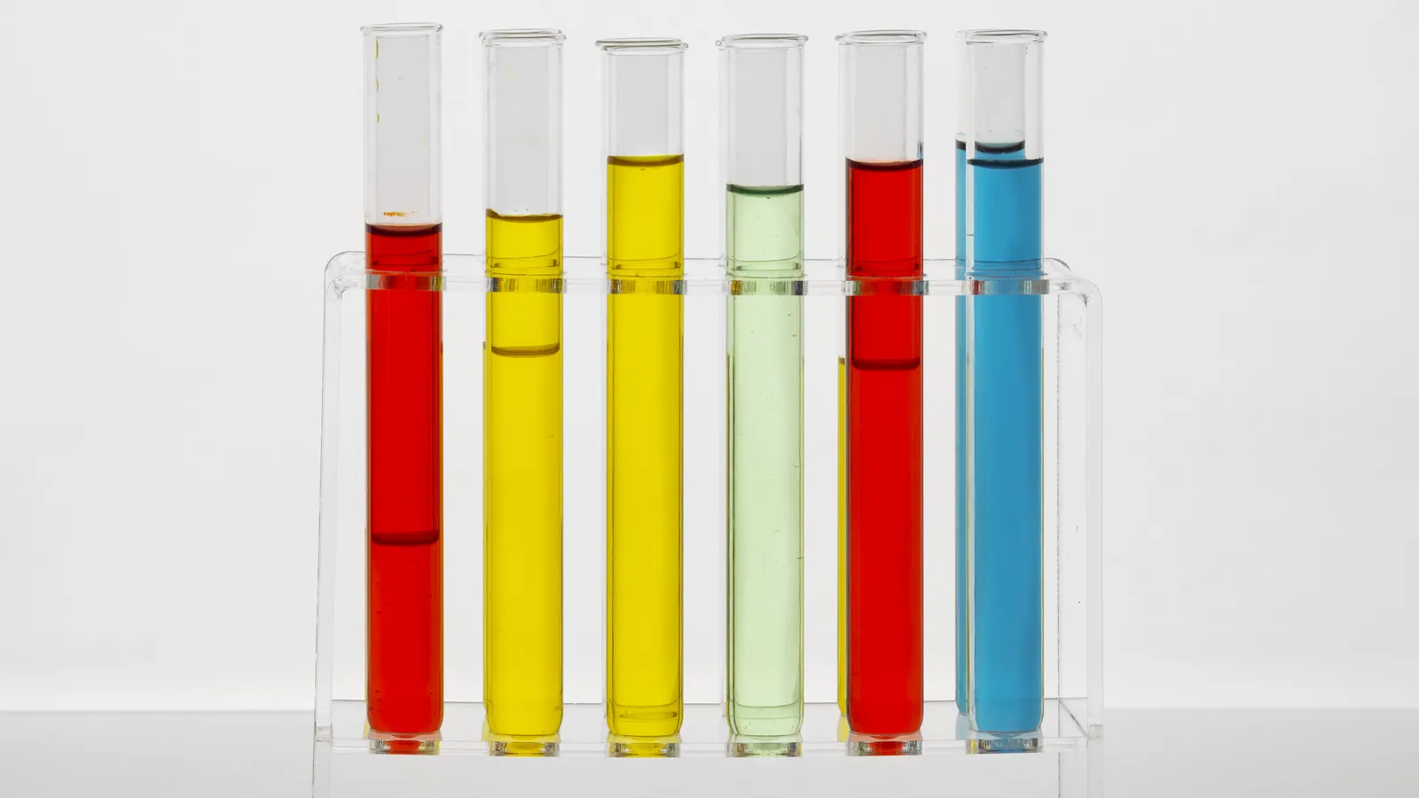 Tubos de ensayo con muestras de colores en una gradilla de laboratorio