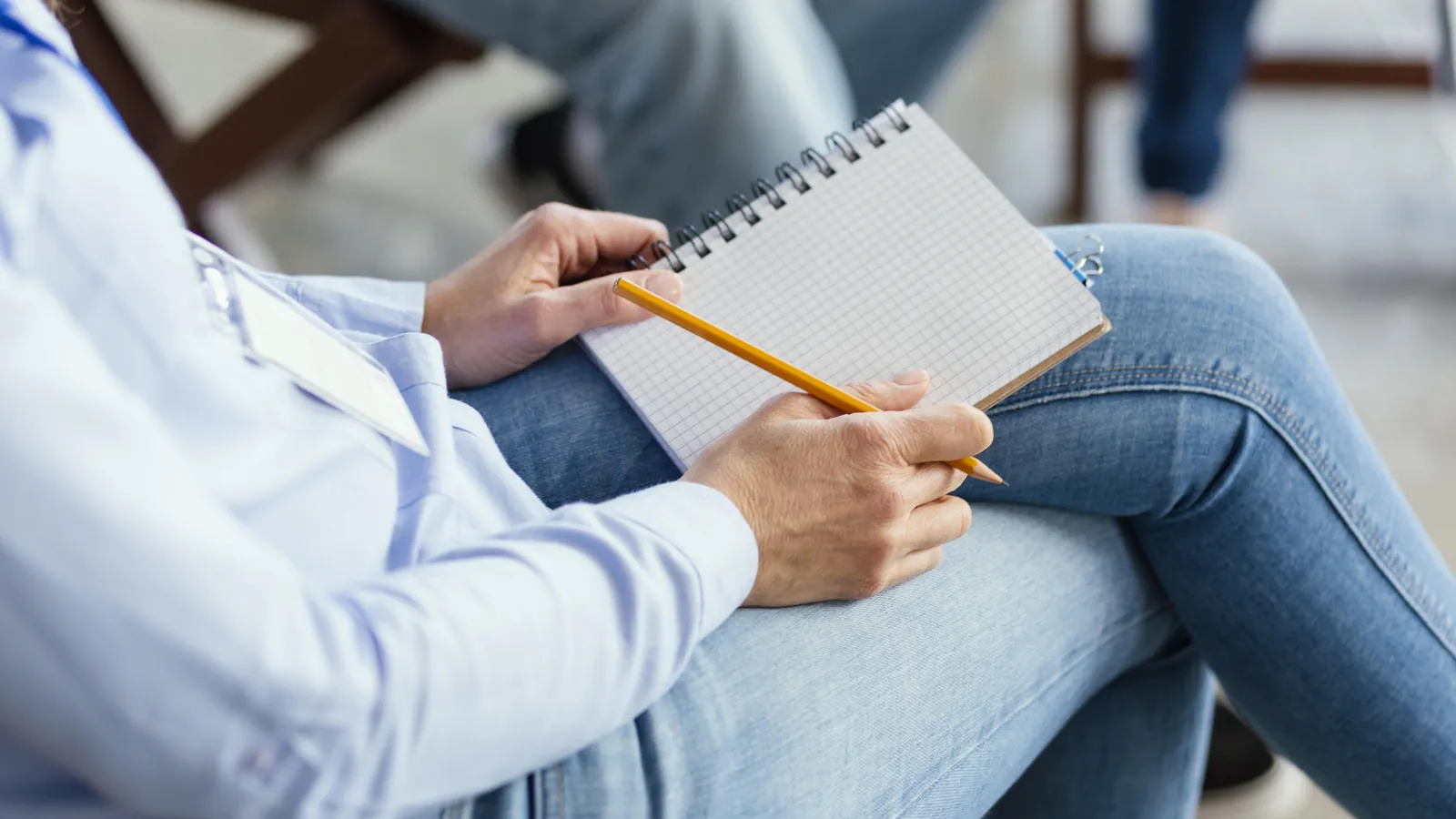 Manos tomando notas a lápiz en una libreta durante una entrevista