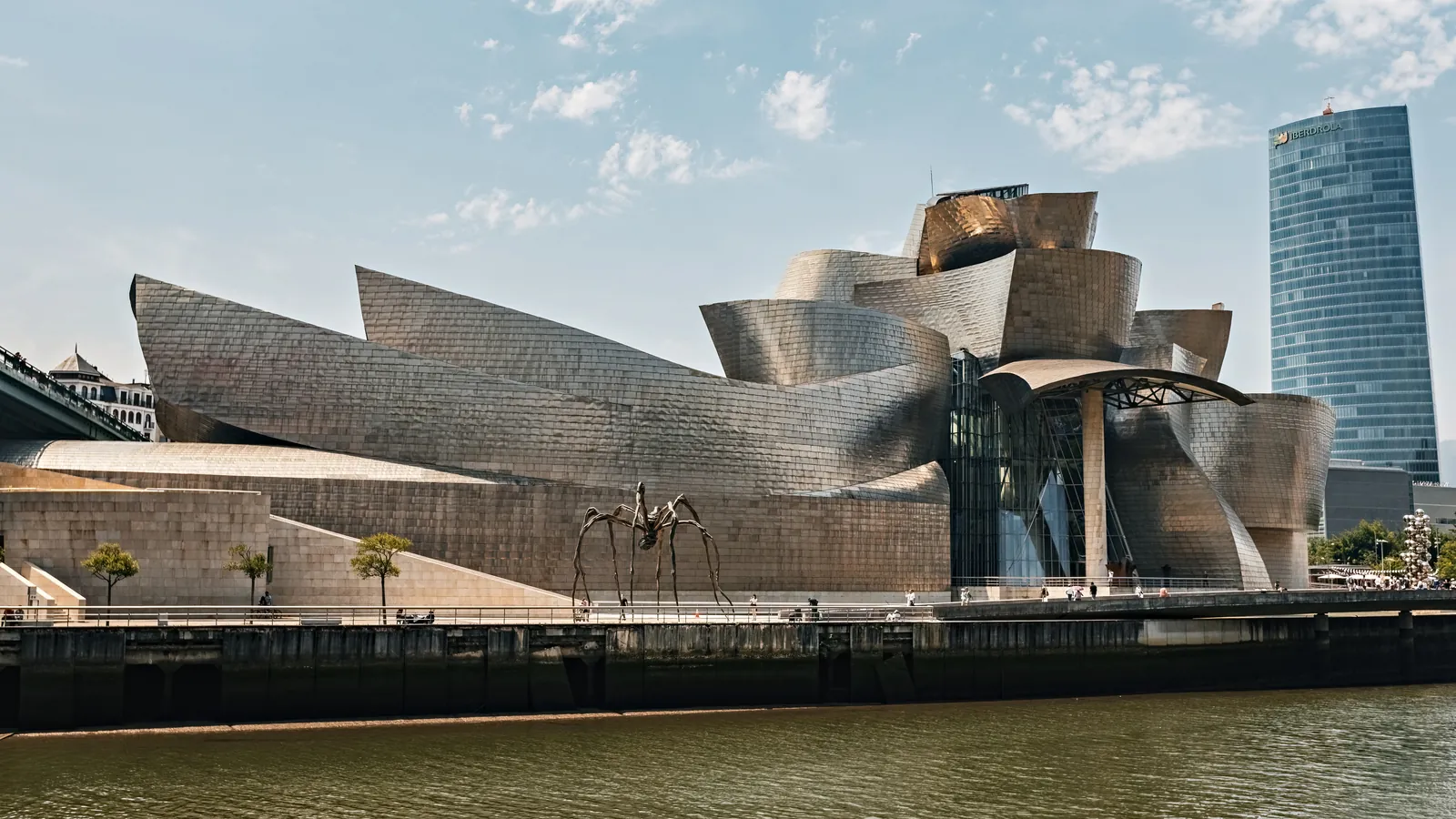 Museo Guggenheim junto a la ría de Bilbao y la torre Iberdrola en un día despejado