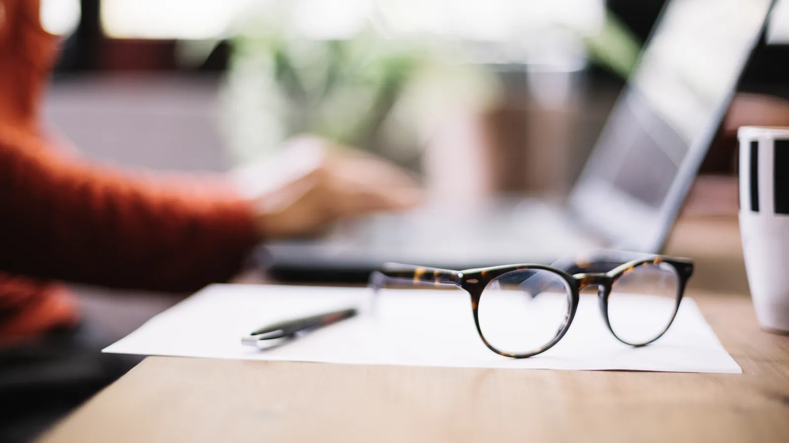 Gafas y bolígrafo sobre un informe en el escritorio de un profesional
